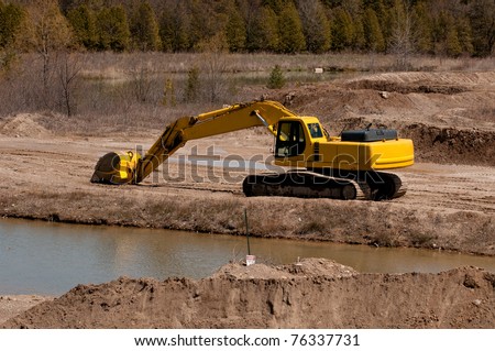 Excavator with a long arm in a sand quarry