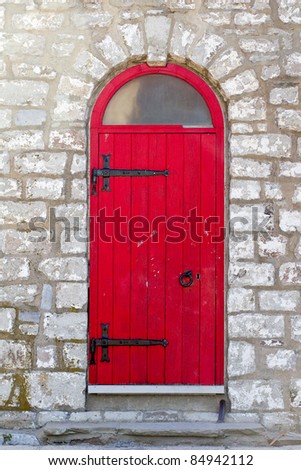 Old red door on a stone building