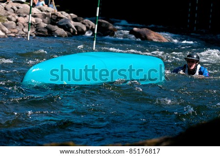 MINDEN, ONTARIO - SEPT 10:  An unidentified contestant swims after the overturned canoe at Open Canoe Slalom Race, 2011 at Gull River in Minden, Ontario, Canada.