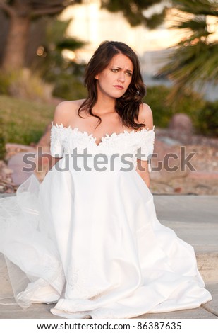 Sad bride sitting on the curb