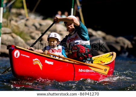 MINDEN, ONTARIO - SEPTEMBER 10: An unidentified contestant and his child compete at 2011 Open Canoe Slalom Race at Gull River in Minden, Ontario, Canada on September 10, 2011.
