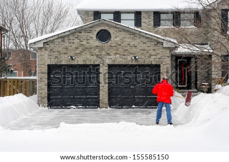 Man Clearing Snow On His Driveway