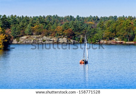 Sailboat on a blue lake in the fall