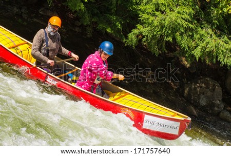 MINDEN, ONTARIO - SEPTEMBER 8: Man and a woman paddling a whitewater canoe at  Open Canoe Slalom Race at Gull River in Minden, Ontario, Canada on September 8, 2013.