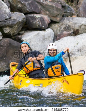 MINDEN, ONTARIO - SEPTEMBER 6, 2014: Two unidentified contestants at 2014 Open Canoe Slalom Race at Gull River in Minden, Ontario, Canada.