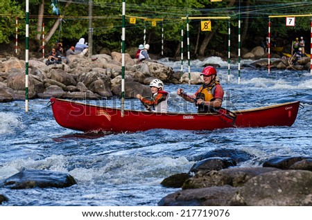 MINDEN, ONTARIO - SEPTEMBER 6, 2014: Father and son compete at 2014 Open Canoe Slalom Race at Gull River in Minden, Ontario, Canada.