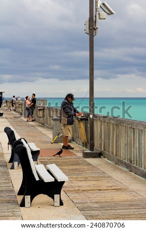POMPANO BEACH, FLORIDA -?? JANUARY 26, 2011: Tourists and fishermen standing on the Pompano Beach Fishing Pier. The pier is always open and free for fishing.