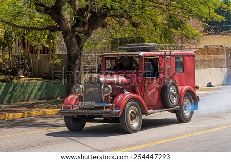 VARADERO - FEB 15: Old classic Ford car with a roof rack and a ladder found on a small residential street in Varadero, Cuba on Febriary 15, 2015