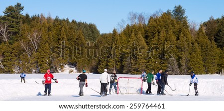 PALGRAVE, ONTARIO - MARCH 8: Boys playing a game of ice hockey on an outdoor skating rink in Palgrave village in Ontario on March 8, 2015.