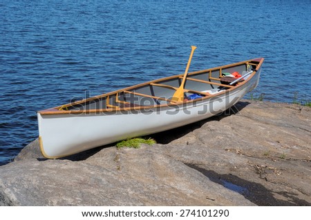 White canoe on a rocky ledge