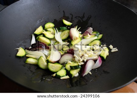 frying onions,garlic and zucchini in a wok pan
