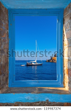 View of a sailing boat threw a window in Santorini island Greece