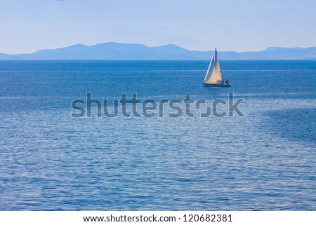 Sailing boat by Mykonos island in cyclades Greece sailing away