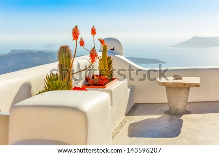 Greece Santorini island in Cyclades, traditional detail sights of colorful flowers with pots and caldera sea in background