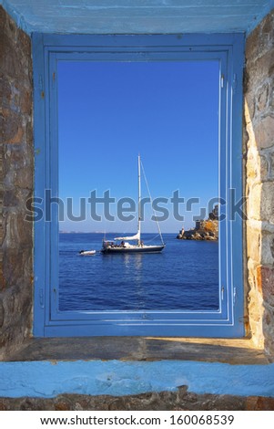 View of a sailing boat  threw a window frame  in Santorini island in Greece Cyclades with the rider