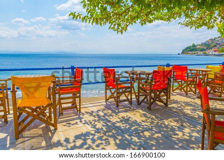 Greece Evoia lake, colorful chairs of a coffee shop by the sea at summer