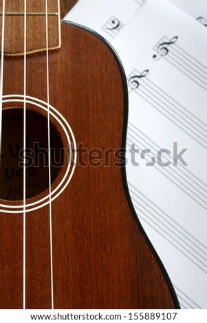 Ukulele fretboard, a part of ukulele haiwaiian  guitar with the music notes paper