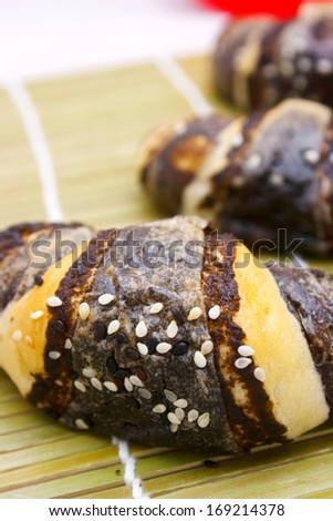 Chocolate croissant with white sesame on bamboo background