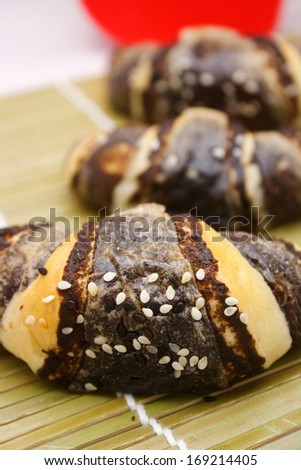 Chocolate croissant with white sesame on bamboo background