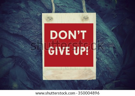 Don't Give Up:  Inspiration Motivational Life Quote on Wood Frame Background Design.