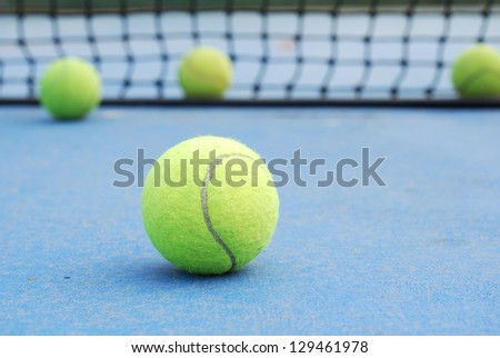 tennis balls on court field with net