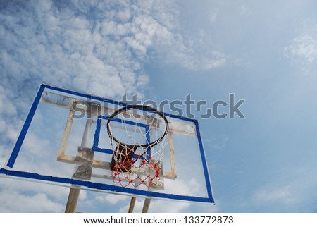 Old acrylic basketball board with a blue sky background