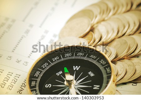 Coins and compass on bank book account in vintage color