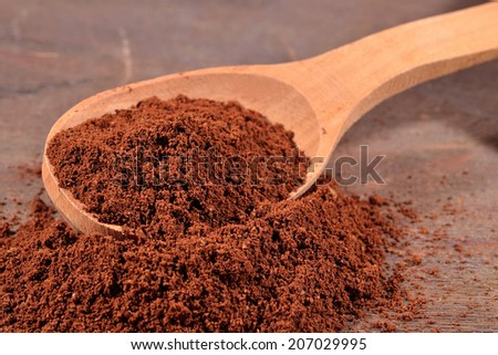 Ground coffee in a wooden spoon