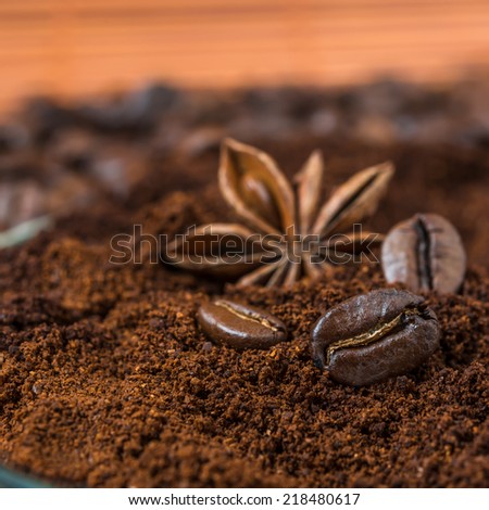 coffee beans and  anise with ground coffee heap.  Arabic roasted coffee with spices. Coffee beans and  ground coffee on ocher background.