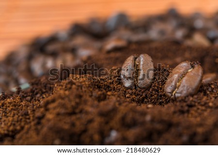 Arabic ground roasted coffee and coffee beans. Coffee beans and  ground coffee on brown background.