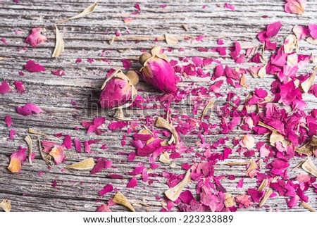 background with rose petals and two dried flowers on old wooden table
