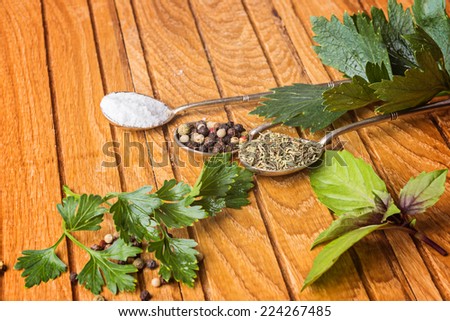 Overhead view of cooking ingredients, spices, herds and oil on a wooden kitchen table.