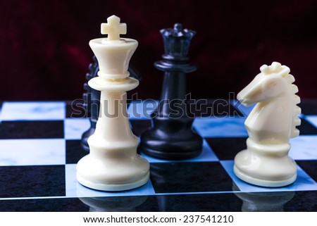 Chess on the chessboard. Black and white chess pieces on blue board