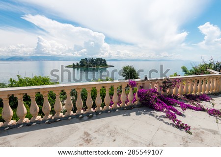 View waterfront  with bougainvillea flowers. Mouse Island, Pontikonissi in Corfu, Greece.