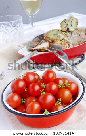Cherry Tomatoes And Cress Sprouts In The Red Metal Bowl, Pork Roast With Garlic And Glass Of White Dry Wine On The Background