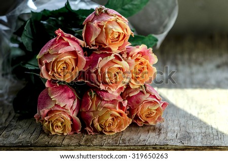 Autumn Ecuador roses on the vintage wooden table, toned