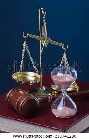 gavel, hourglass and book on blue background