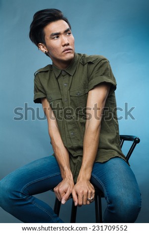 a studio portrait of a young asian male model in stylish casual clothes