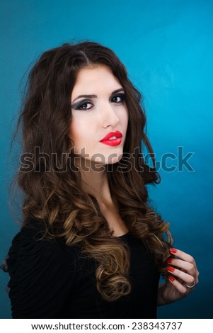 beauty shot of a young brunette woman against blue background