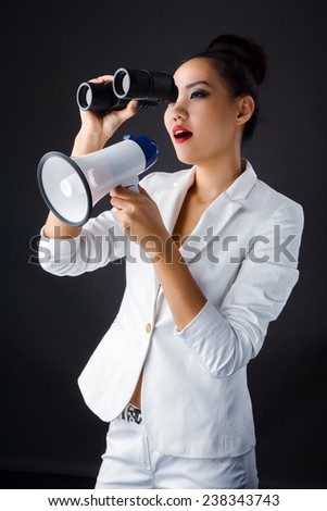 a young attractive woman with binoculars and megaphone