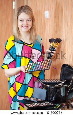 Female visagiste with cosmetics ready for job
