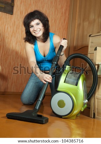 Woman cleaning with vacuum cleaner in living room