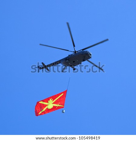 Helicopter with flag in sky