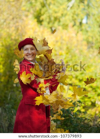 Happy mature woman  throw up maple leaves