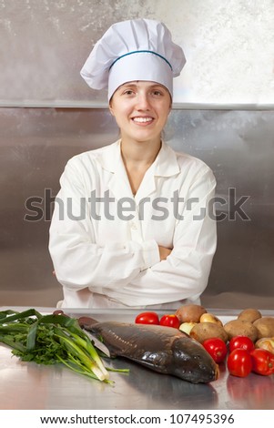 Cook woman  cooking fish  in kitchen