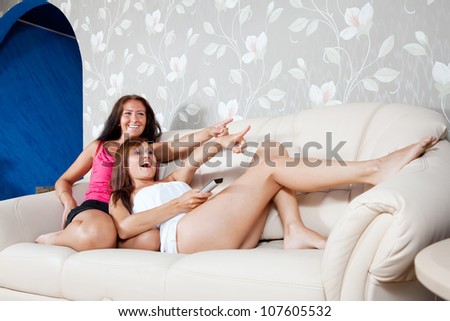 laughing women look cinema laying on sofa