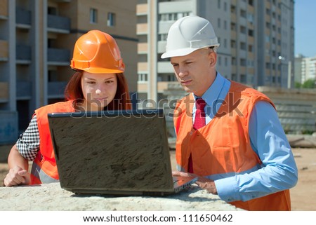 Portrait of two builders works at construction site
