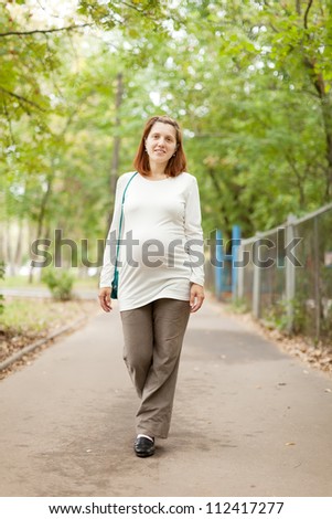 Full length of pregnant woman walking on street