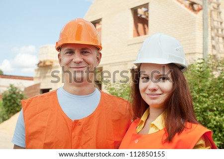 Portrait of two builders works at construction site