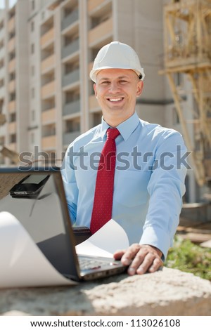 Happy builder in hardhat works on the building site